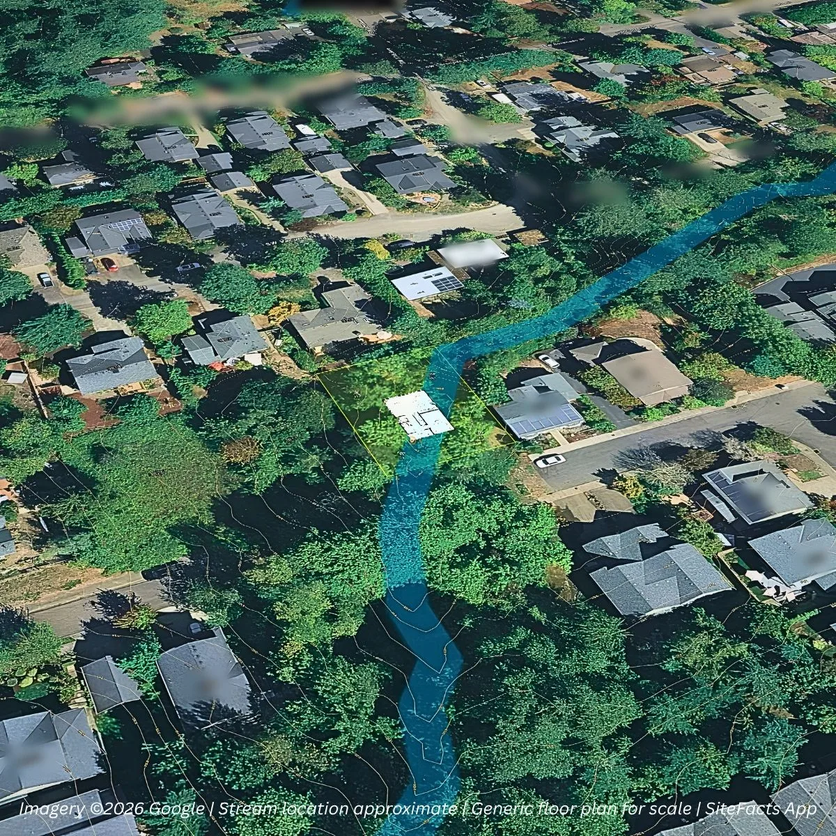 Oblique aerial of a wooded infill lot in an established neighborhood, with an approximate creek path in blue cutting diagonally through the parcel and a generic floor plan for scale